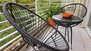 Una silla negra sentada en un balcón con un tazón. en Miller y Olazábal en Buenos Aires