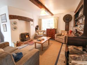 een woonkamer met een bank en een tafel bij The Cottage in Holywell
