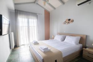 a bedroom with a large bed with towels on it at Green Garden in Porto Heli