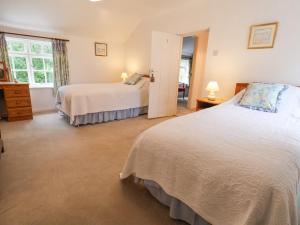 a bedroom with two beds and a window at The Cottage in Holywell