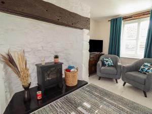 a living room with a fireplace and two chairs at Teulu in Llangollen