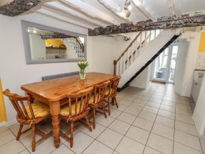 Un comedor con mesa y sillas de madera. en Teulu, en Llangollen