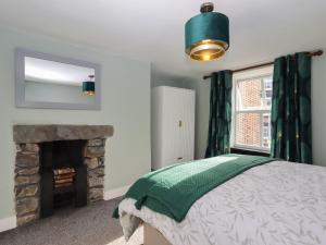 Un dormitorio con una cama y una chimenea. en Teulu, en Llangollen