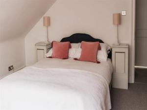 Schlafzimmer mit einem weißen Bett und roten Kissen in der Unterkunft Pass the Keys The Top Space in Hastings
