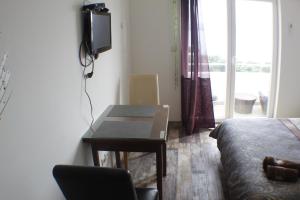 ein Zimmer mit einem Bett, einem Tisch und einem Fernseher in der Unterkunft A3 Mesic in Igrane