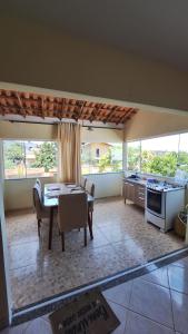 uma sala de estar com uma mesa e uma cozinha em casa suite cabo frio em Cabo Frio