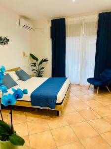 um quarto com uma cama e uma cadeira azul em Casa Saline em Tarquinia