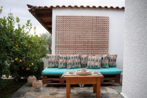 a couch with pillows sitting on a patio at Green Garden in Porto Heli