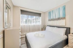 um quarto com uma cama grande e uma janela em Pass the Keys Whitechapel Central Apartment em Londres