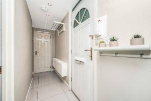 uma casa de banho com uma porta branca e piso em azulejo branco em Pass the Keys Whitechapel Central Apartment em Londres