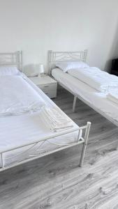 two white beds in a room with wooden floors at Ferienwohnungen in Köln 0904 in Cologne