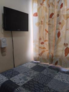 - une chambre avec une télévision murale à écran plat dans l'établissement Nely y Pietro share apartment, à Punta Cana