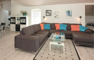 FlovtにあるGorgeous Home In Haderslev With Kitchenのリビングルーム(ブラウンソファ、オレンジ&ブルーの枕付)