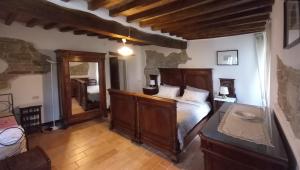 a bedroom with a wooden bed and a mirror at La Corte Bonomini in Neviano degli Arduini