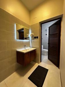 uma casa de banho com um lavatório, um espelho e um WC. em شقق أبياتي em Khamis Mushayt