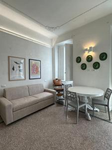een woonkamer met een bank en een tafel bij Palazzo Pilo in Sassari
