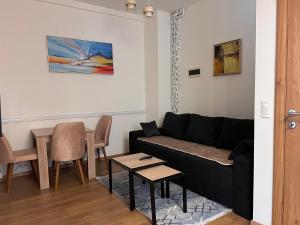 a living room with a black couch and a table at Old Town Vip Apartment in Novi Pazar