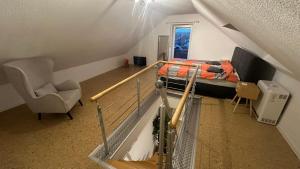Cette chambre mansardée comprend un lit et une chaise. dans l'établissement 140 qm Maisonette-Whg ruhig und doch zentral, à Florstadt