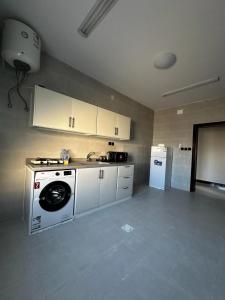 uma cozinha com uma máquina de lavar roupa e um frigorífico em شقق أبياتي em Khamis Mushayt