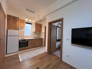 cocina con electrodomésticos blancos y TV de pantalla plana. en Old Town Vip Apartment, en Novi Pazar 3 fotos más