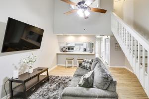 a living room with a couch and a flat screen tv at Updated Tallahassee Townhome 3 Mi to Downtown! in Tallahassee