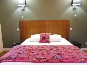 a bedroom with a bed with a pink comforter at La Stazione in Nogent-le-Rotrou