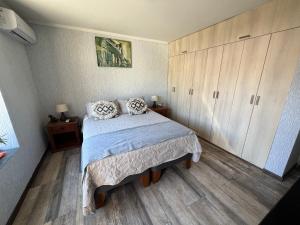 a bedroom with a bed and wooden floors and cabinets at Departamento Studio - Carrera - Factura - Central - Empresas in Chillán