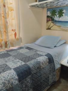 una camera con letto e una foto di una spiaggia di Nely y Pietro share apartment a Punta Cana