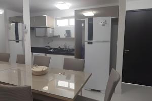 a kitchen with a white refrigerator and a sink at Frente Mar Bessa João Pessoa in João Pessoa