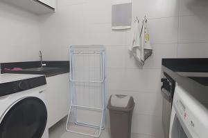 a bathroom with a towel rack next to a washing machine at Frente Mar Bessa João Pessoa in João Pessoa