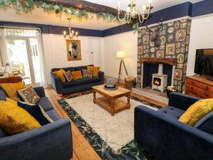 a living room with blue couches and a fireplace at Liberty House in Ashbourne