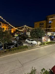 a street with cars parked in a parking lot with lights at Antica dimora in Borgo a Buggiano