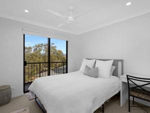 a white bedroom with a bed and a balcony at Gold Coast best holiday resort, perfect location ! in Gold Coast +28 photos
