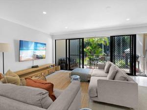a living room with two couches and a tv at Gold Coast best holiday resort, perfect location ! in Gold Coast