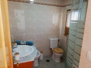 a bathroom with a toilet and a sink at Albanta in Chipiona +24 photos