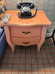 une table orange avec un téléphone en haut dans l'établissement The Adler a Hollywood Hotel, à Los Angeles