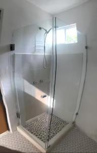 y baño con ducha y puerta de cristal. en Casa Redonda Hostal Inn 1 en Isla Holbox