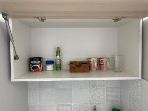 ein Regal mit verschiedenen Gegenständen in einer Küche in der Unterkunft Departamento Studio - Carrera - Factura - Central - Empresas in Chillán