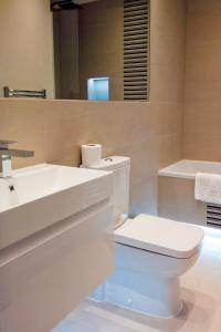 a bathroom with a toilet and a sink and a mirror at Madison Hill - Fernlea Garden 8 - One bedroom home in London