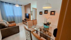 a living room with a table and a couch at Apto 400m UEL, 2 quartos, ar condicionado egaragem in Londrina