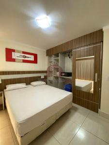 a bedroom with a large bed and a bathroom at L'acqua diRoma 12345 / CN - Adriele in Caldas Novas