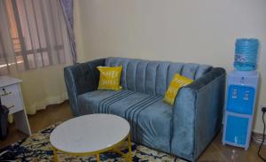 een blauwe bank met gele kussens in de woonkamer bij Jay Jay homes in Ruaka