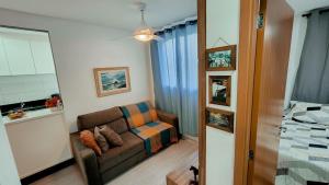 a living room with a couch and a bed at Apto 400m UEL, 2 quartos, ar condicionado egaragem in Londrina +30 photos