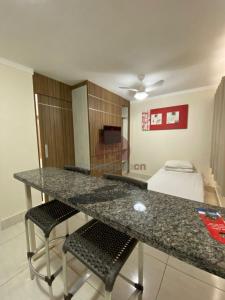 una cucina con tavolo e sedie e una camera di L'acqua diRoma 12345 / CN - Adriele a Caldas Novas