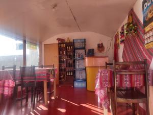 comedor con mesa y algunas sillas en Uros Tupirmarka Lodge Perú, en Puno