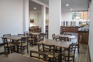 a dining room with wooden tables and chairs at Hotel Serra Negra in Betim