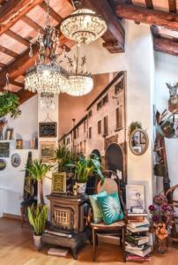 トレヴィーゾにあるロカンダ サン トマソのシャンデリアと植物のあるリビングルーム