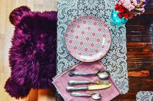 una borsa rosa con cucchiai e un piatto su un tavolo di Locanda San Tomaso a Treviso