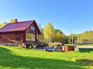 a barn in a field with a green yard at FOREST RIVER RESORT in Vilnius