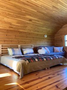 a bed in a room with a wooden ceiling at FOREST RIVER RESORT in Vilnius